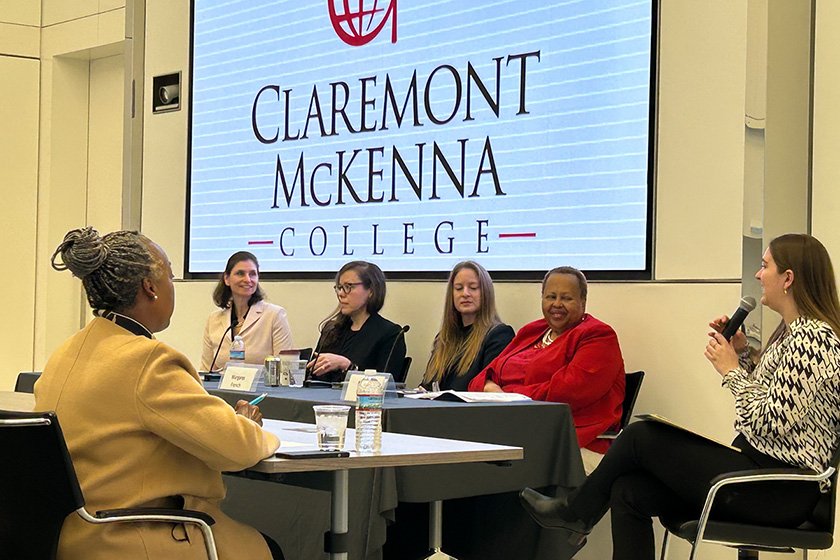 Panelists and the moderator seated at a table for discussion.