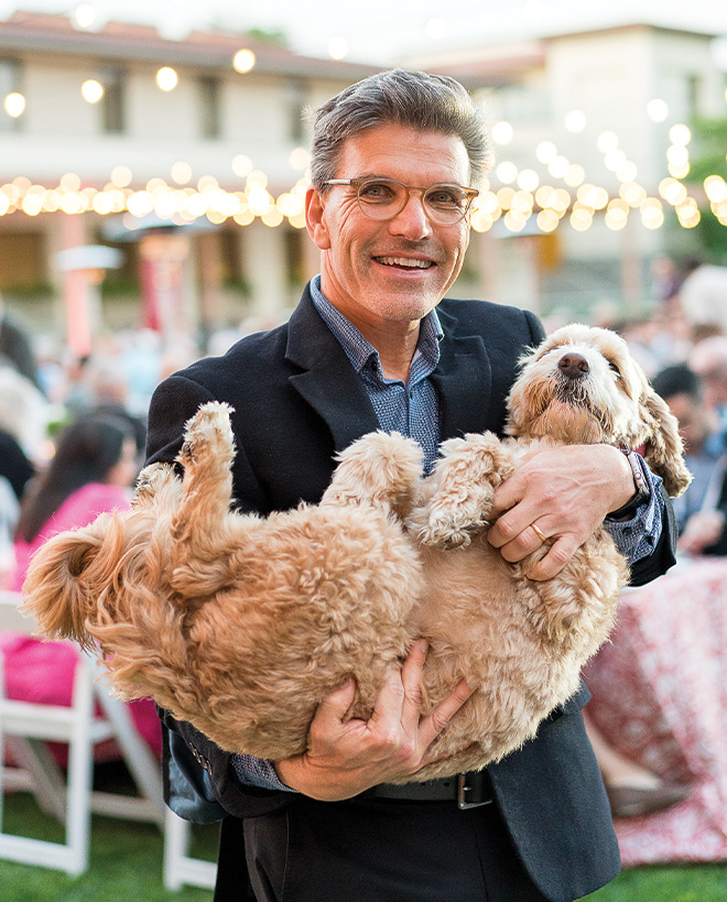 President Chodosh cradling his dog, Theo.