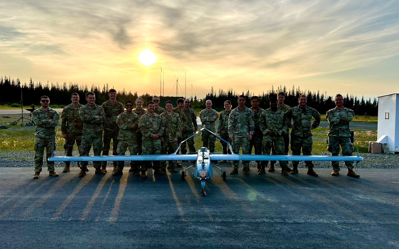 Robin amongst a lineup of her peers standing behind a drone plane.