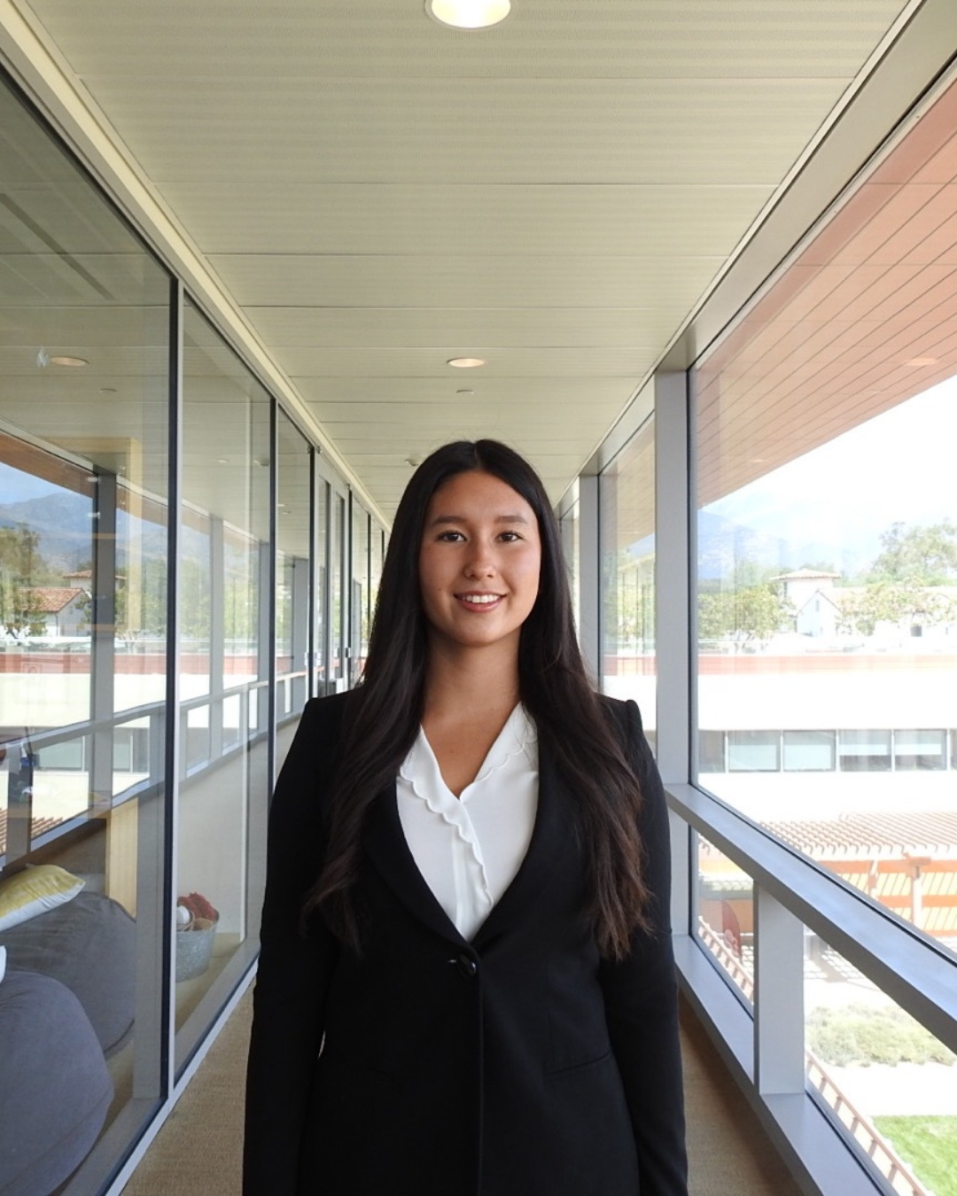Girl with black blazer and white top with long black hair.