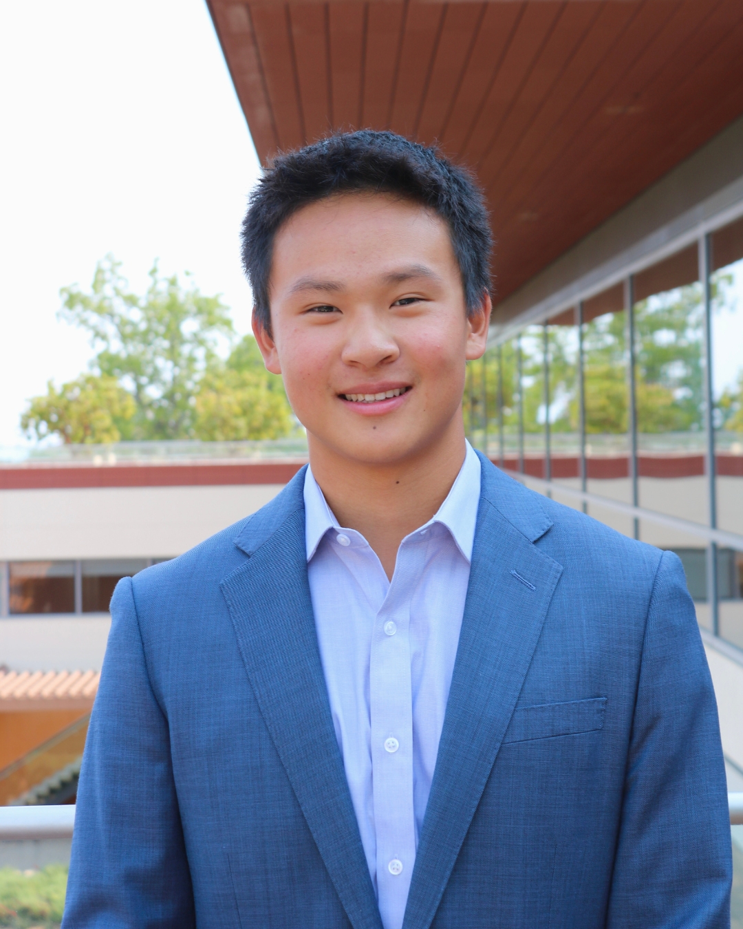 Man in blue suit with short black hair.