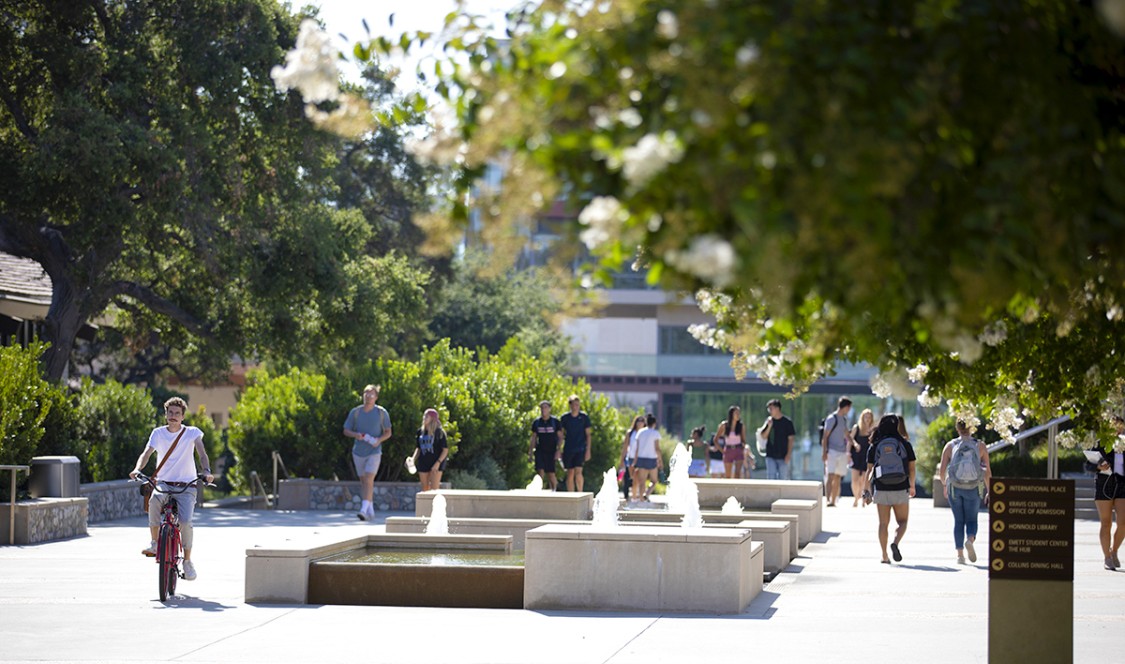 Students on campus among trees and fountains