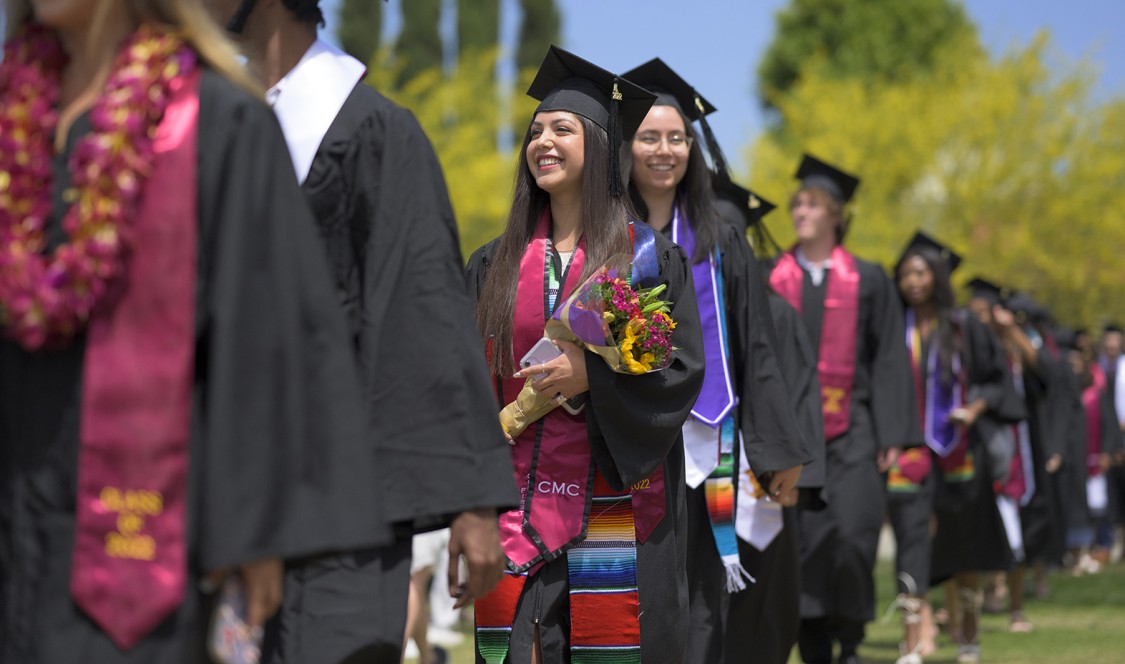 About-to-be graduates walk in a single file procession to the Commencement tent in 2022.