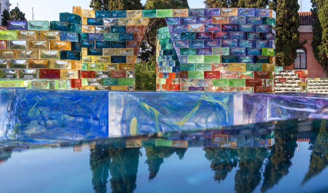 A close-up of the bricks shows polychromatic marbling within the glass. Behind is a frontal view of one of the hexagonal archways for Qwalala.
