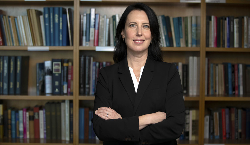 Prof. Shanna Rose in front of bookcase