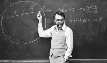 Black and white photo of Professor Henry teaching in front of a chalkboard