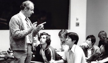 In a black and white photo, Professor John Ferling addresses his seated students during class.