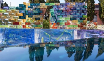 A close-up of the bricks shows polychromatic marbling within the glass. Behind is a frontal view of one of the hexagonal archways for Qwalala.