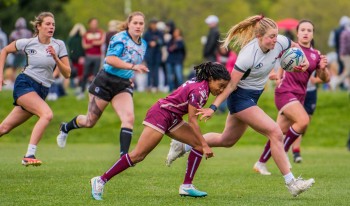 Caroline Bullock running with the ball in rugby match