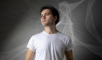 Ian Baine front of a projection of his computational art piece