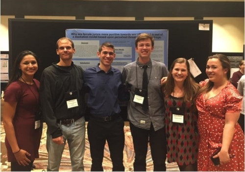 Dr Krauss with his research assistants presenting a poster