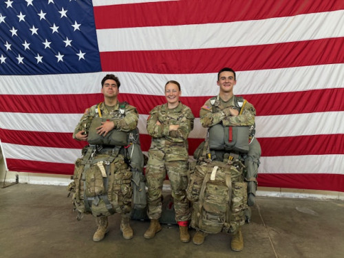 Lauryn Jeans '24 poses with friends in front of the US flag.