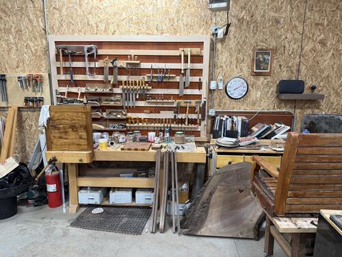 Wood working items on table and shelved wall.