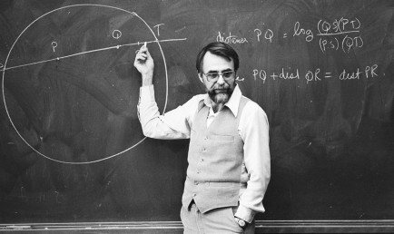 Black and white photo of Professor Henry teaching in front of a chalkboard