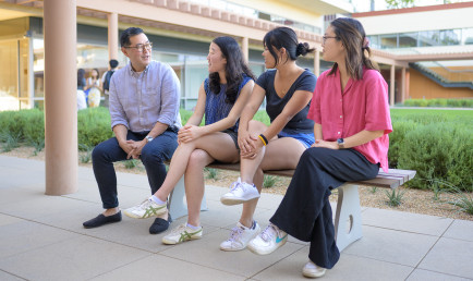Prof. Albert Park sits with students in front of Kravis Center.