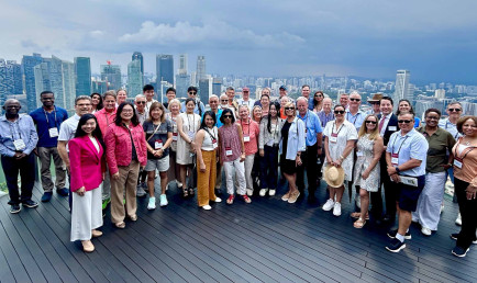 CMC Worldmeet Singapore group on building terrace.