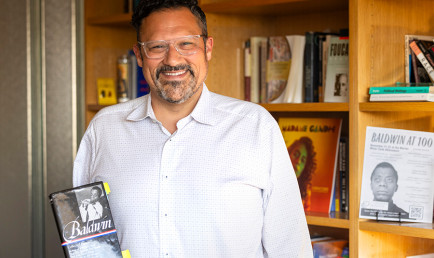 Nicholas Buccola holding a James Baldwin's book.