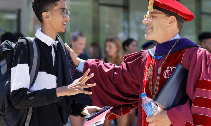 Hiram speaking with a student outside Roberts Pavilion.