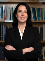 Woman in black suit with crossed arms